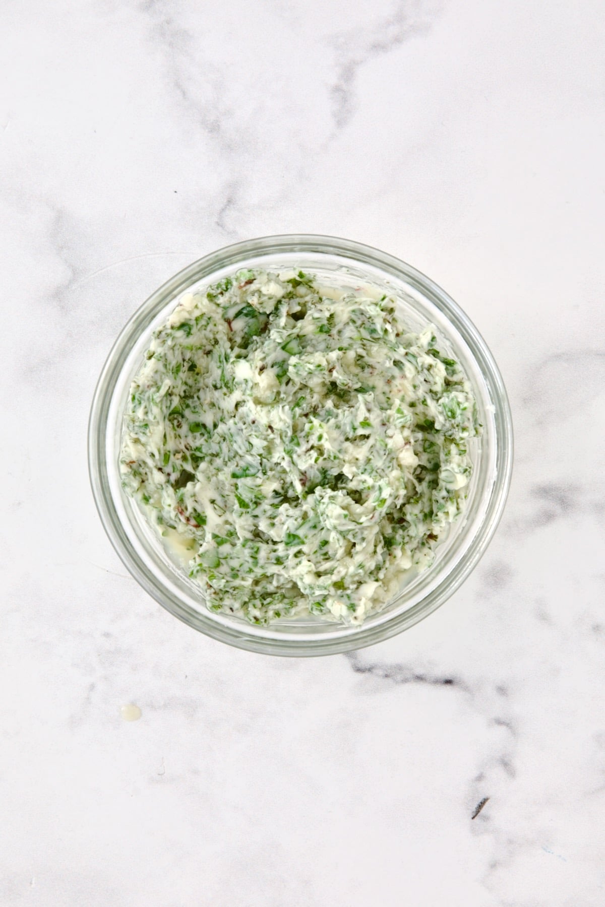 Herb butter in glass bowl.