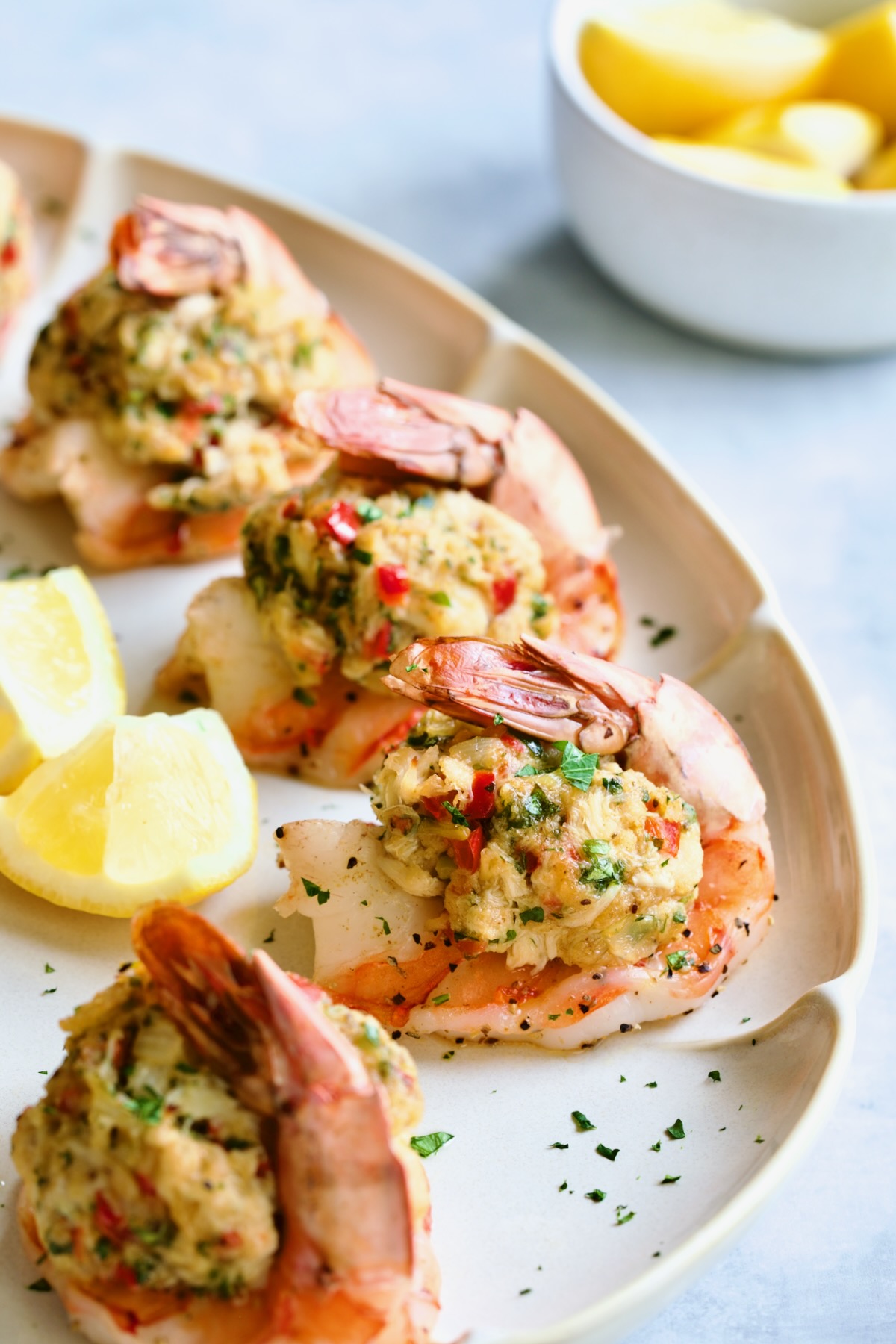 Crab-Stuffed Shrimp on oval white platter garnished with parsley and lemon wedges.