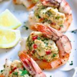 Crab-Stuffed Shrimp on oval white platter garnished with parsley and lemon wedges.