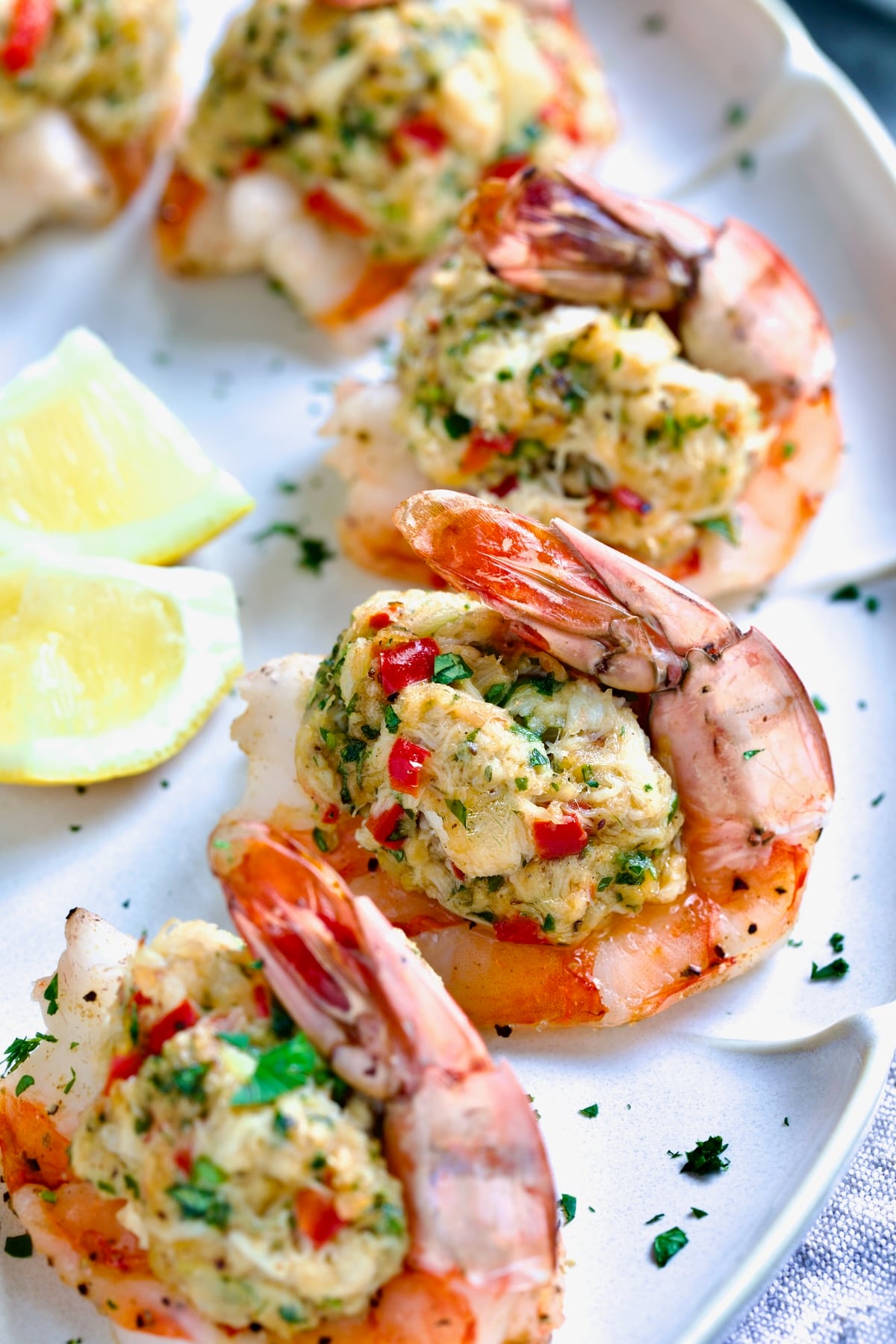 Crab-Stuffed Shrimp on oval white platter garnished with parsley and lemon wedges.