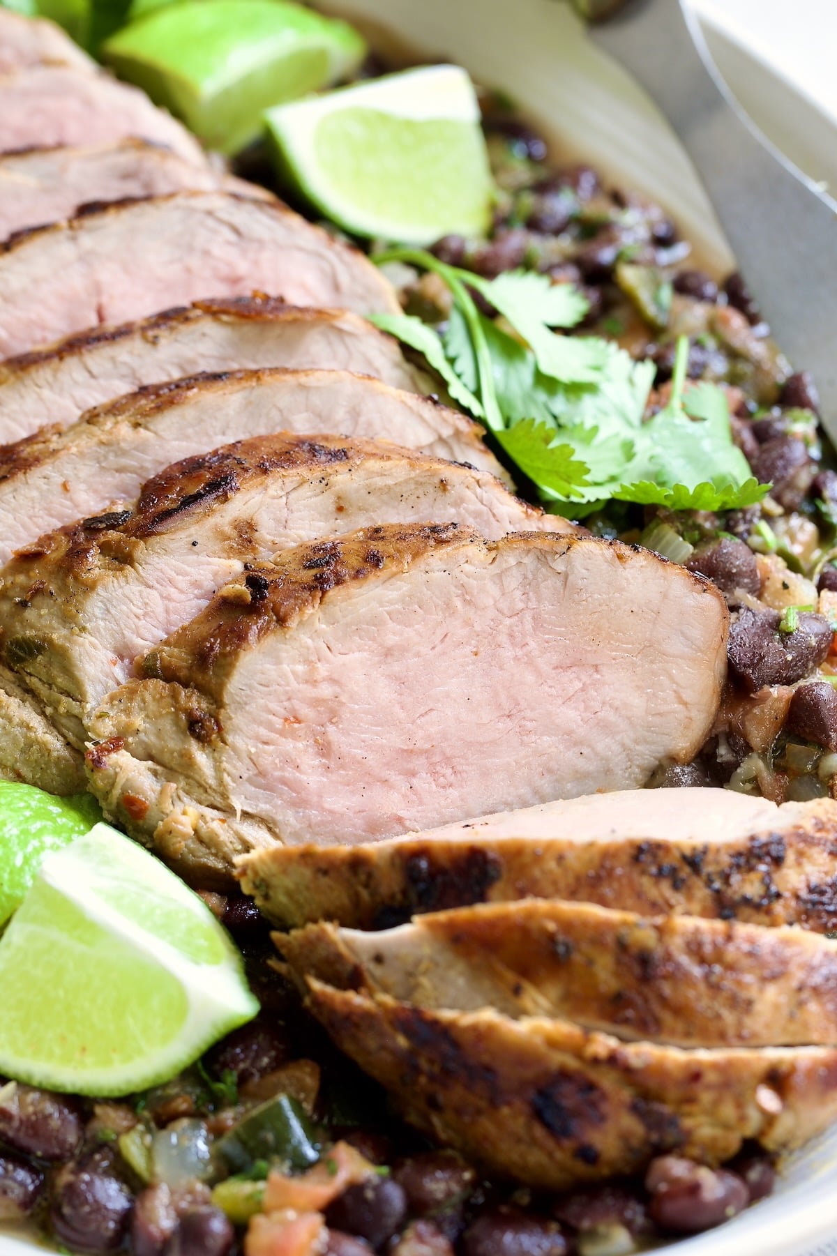 Cuban-Style Pork Tenderloin with Black Beans on oval white platter.