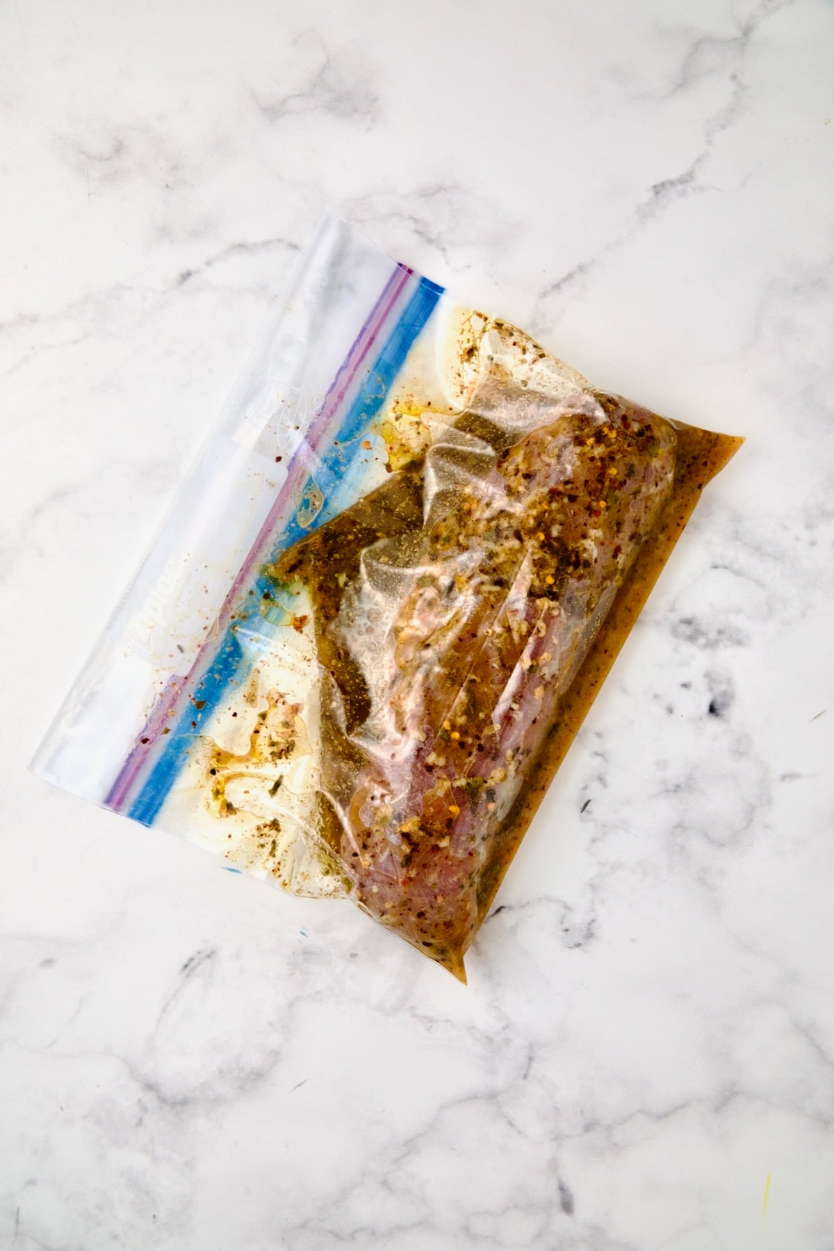 Marinade and pork tenderloin in gallon-size zipper-top bag.