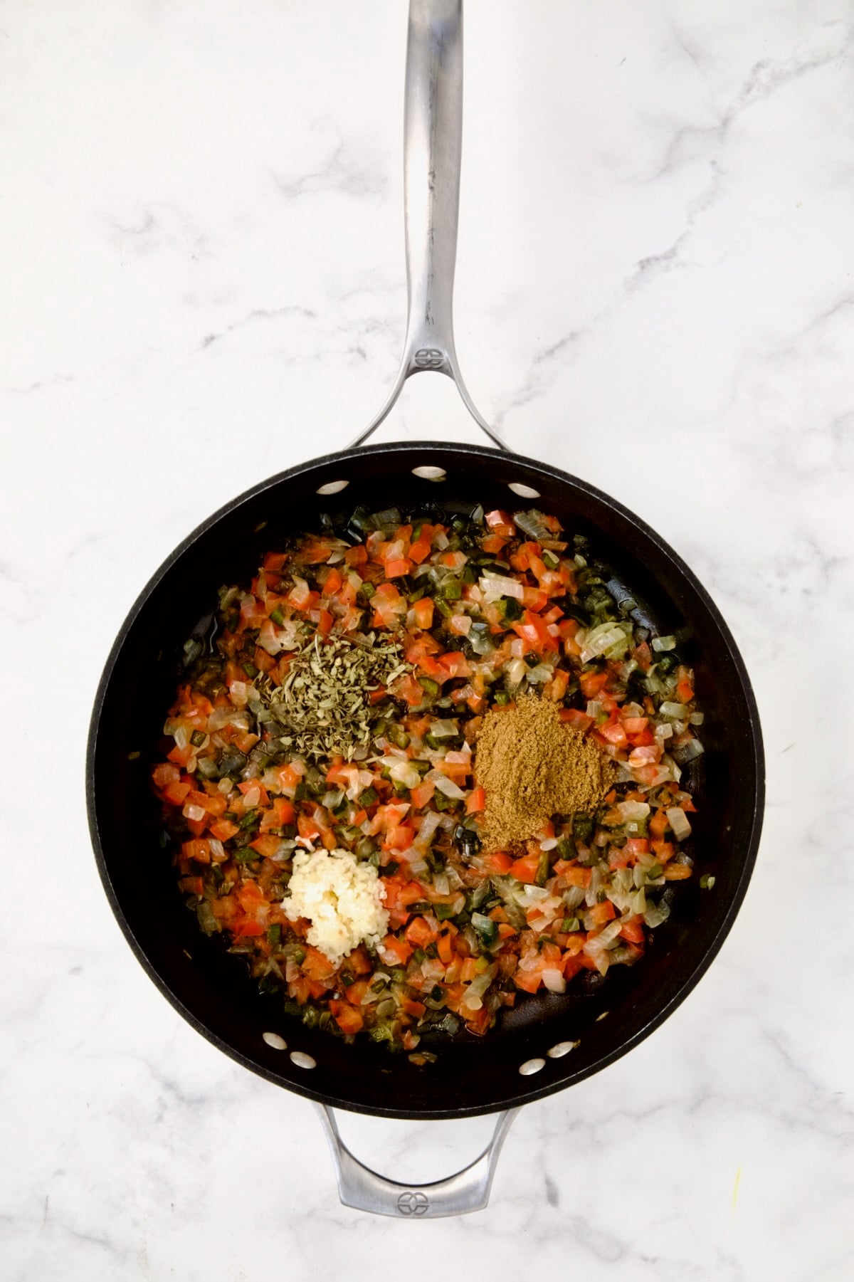 Spices added to onion, Poblano and tomatoes in nonstick skillet.