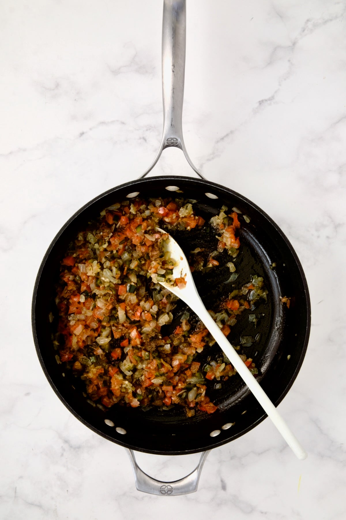 Spices stirred into onion, Poblano and tomatoes in nonstick skillet.