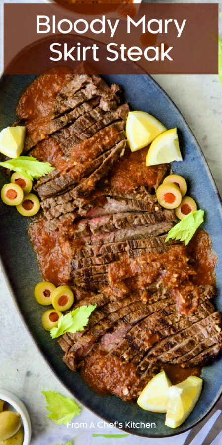Pinterest graphic for Bloody Mary Skirt Steak showing it on a blue platter garnished with lemon wedges, celery leaves and sliced green olives.