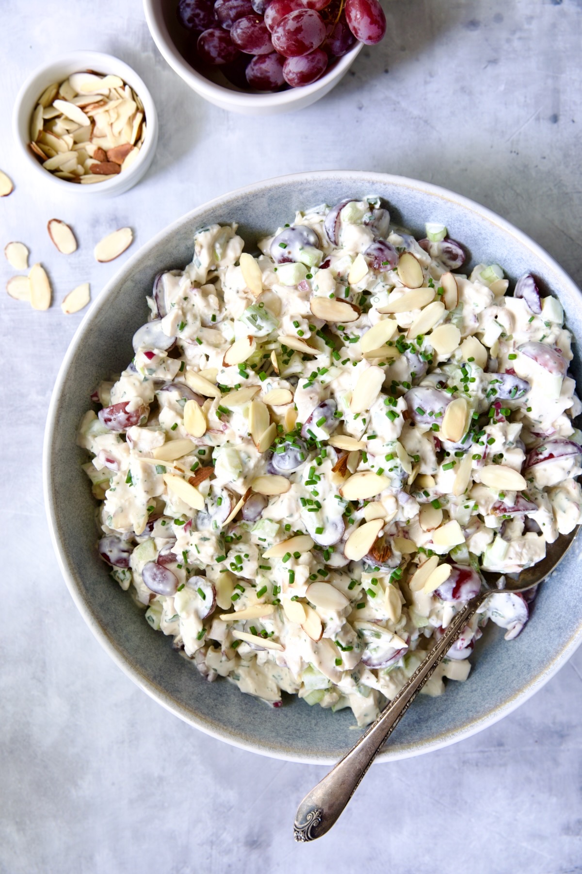 Chicken salad in blue bowl with serving spoon.