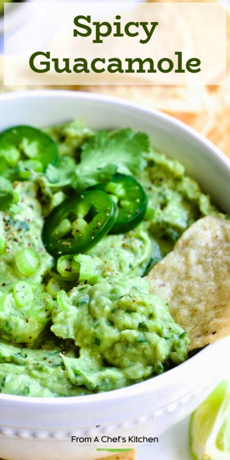 Pinterest graphic for Spicy Guacamole showing it in a white bowl surrounded by tortilla chips, garnished with jalapeno slices and cilantro leaves.