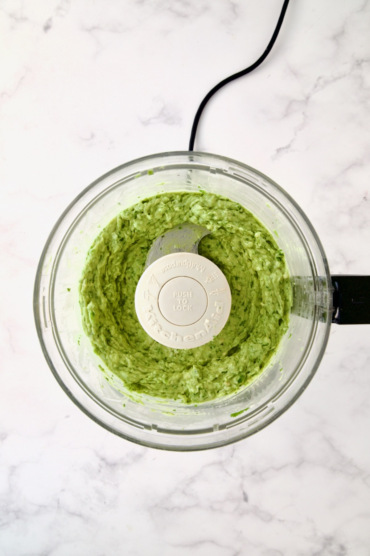 Ingredients for guacamole in food processor before being combined.