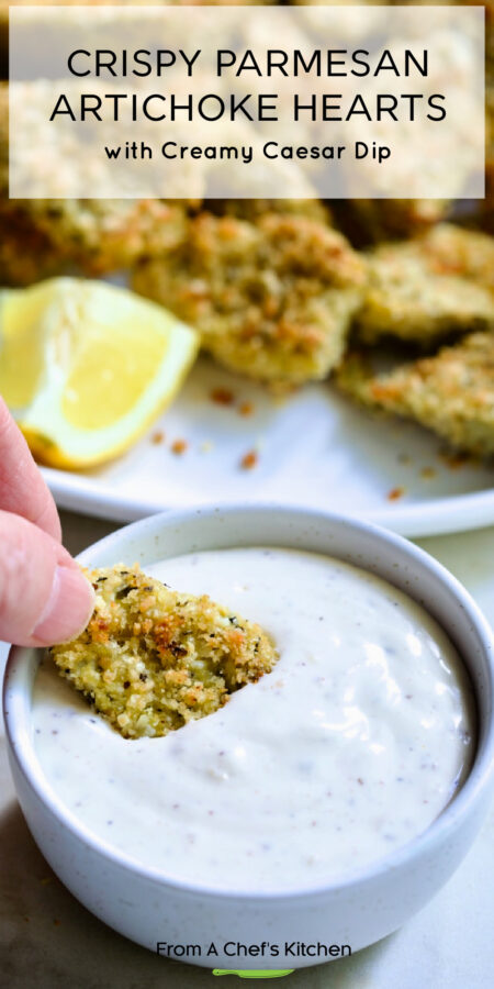 Pinterest graphic for Crispy Parmesan Artichoke Hearts showing a hand dipping one into the creamy Caesar Dip.