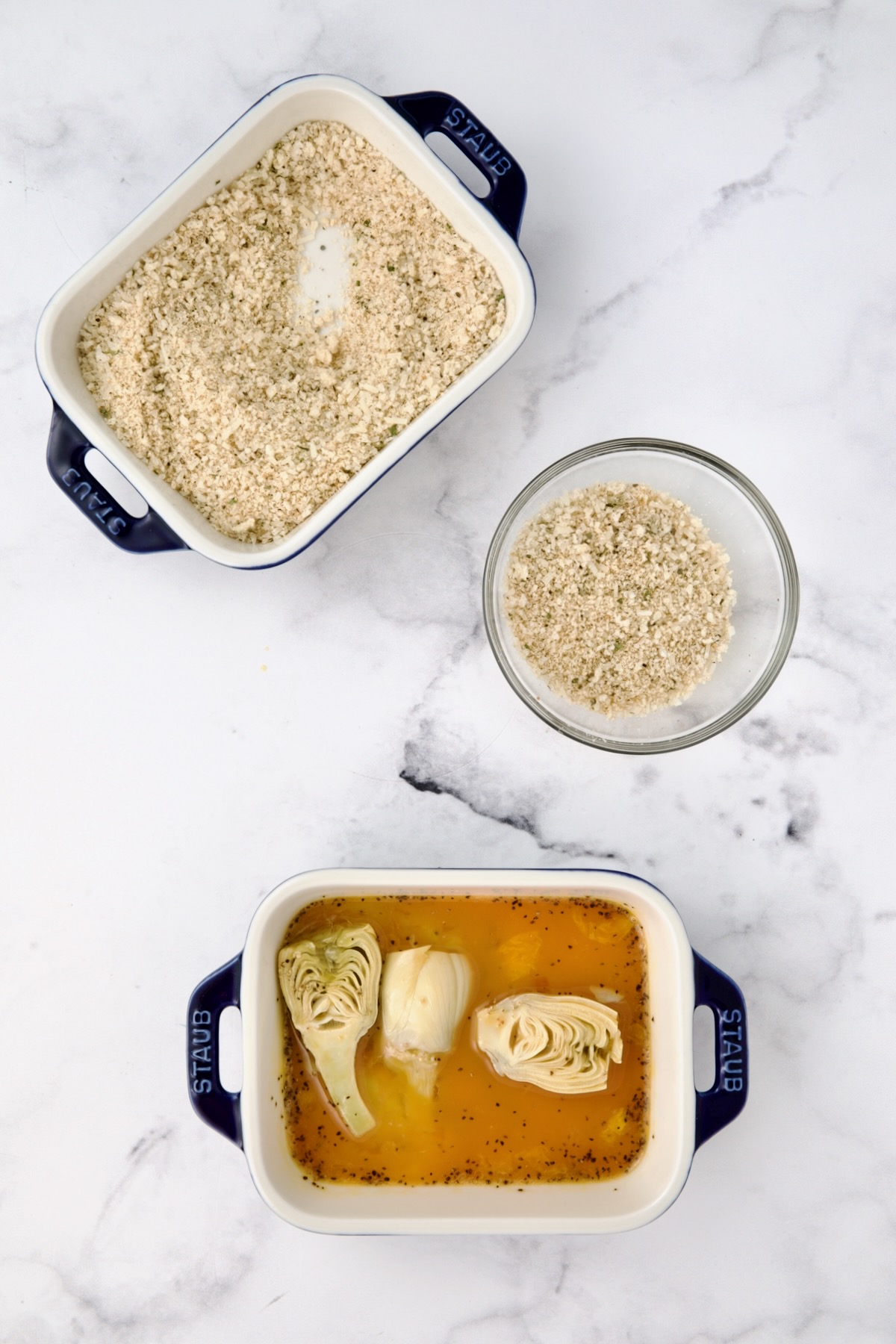 Three containers with breadcrumbs in two, and eggs in a third.