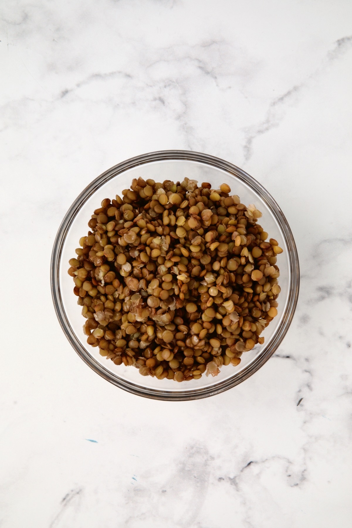 Cooked lentils in glass bowl.