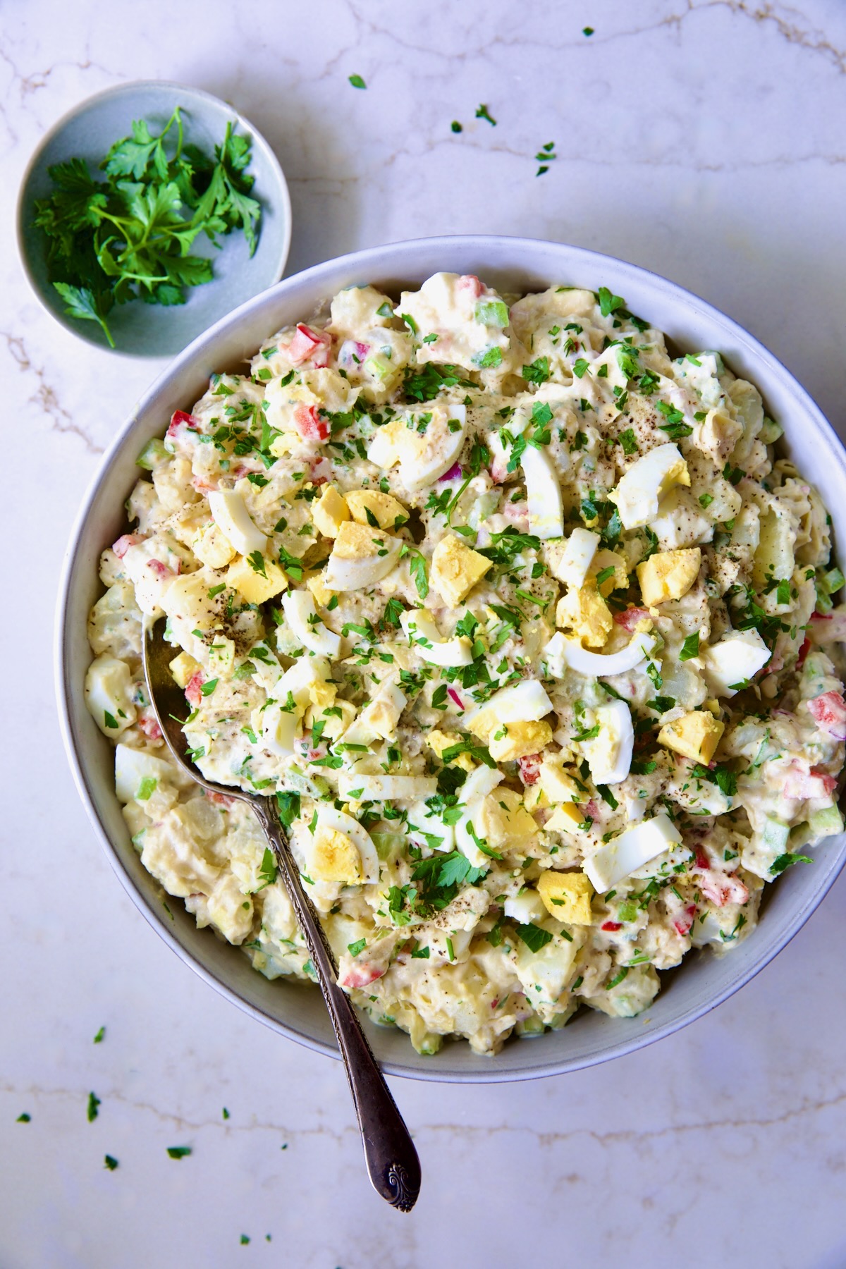 Potato Salad with Horseradish Dressing in light blue bowl with serving spoon.