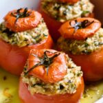 Four Cheesy Rice Stuffed Tomatoes in white baking dish.