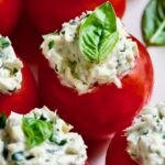 Cream Cheese and Artichoke Stuffed Tomatoes garnished with fresh basil leaves.