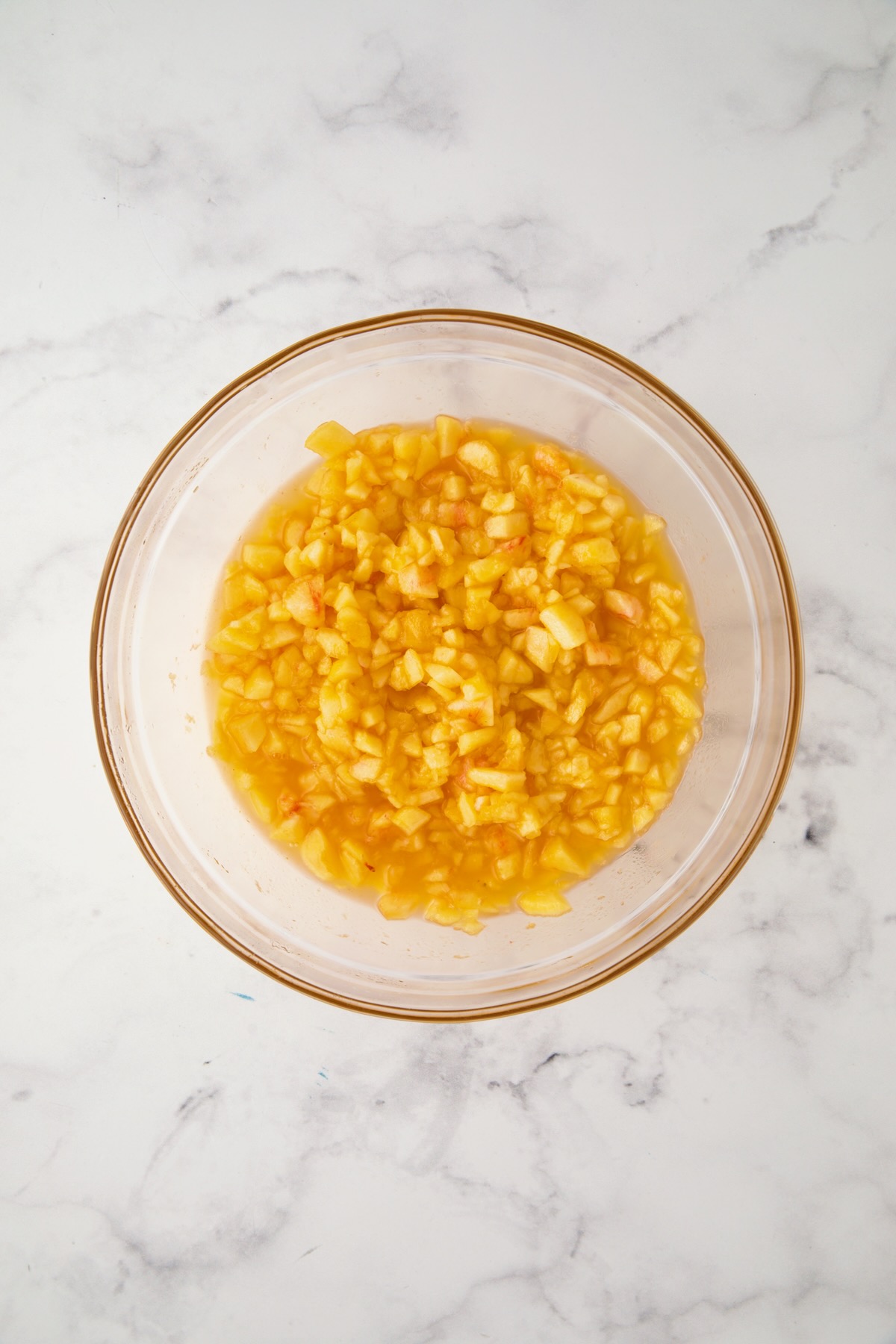Chopped peach pieces in glass bowl.