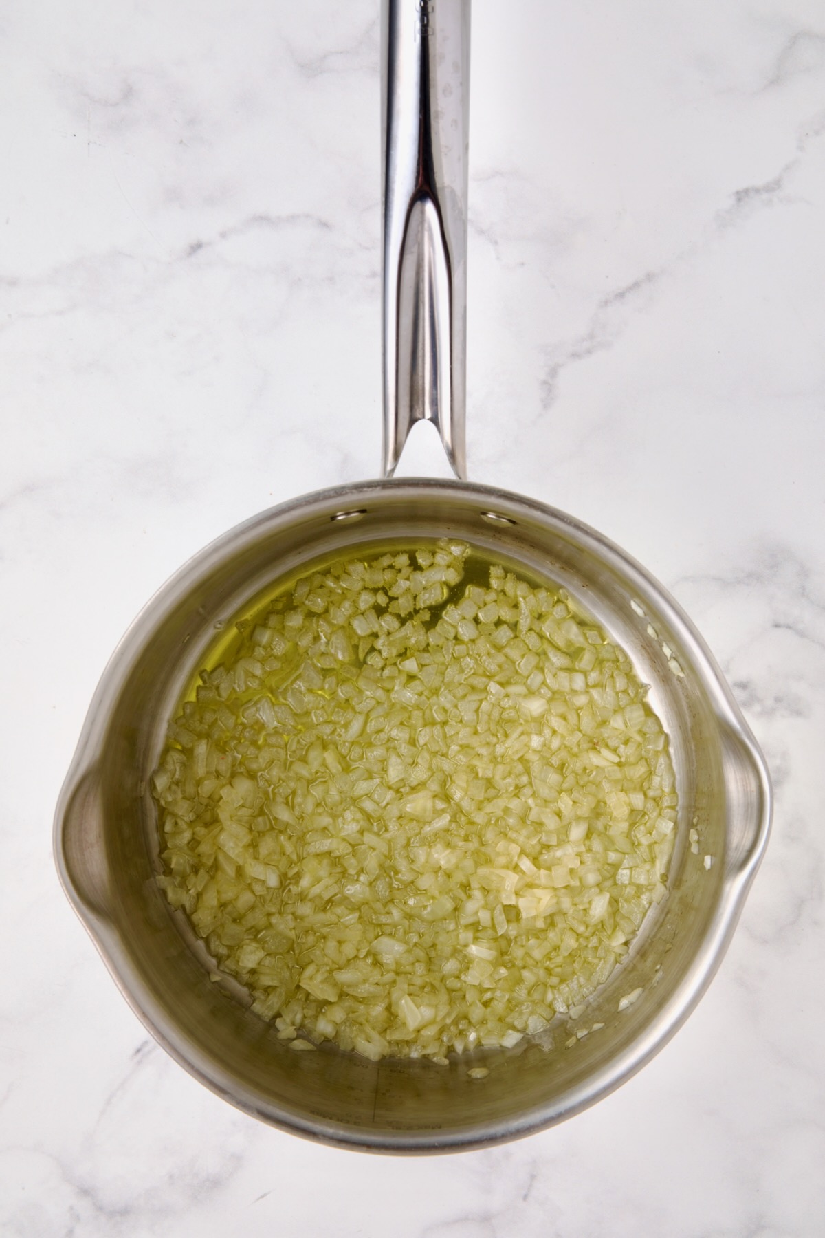 Cooked onion in olive oil in stainless steel saucepan.