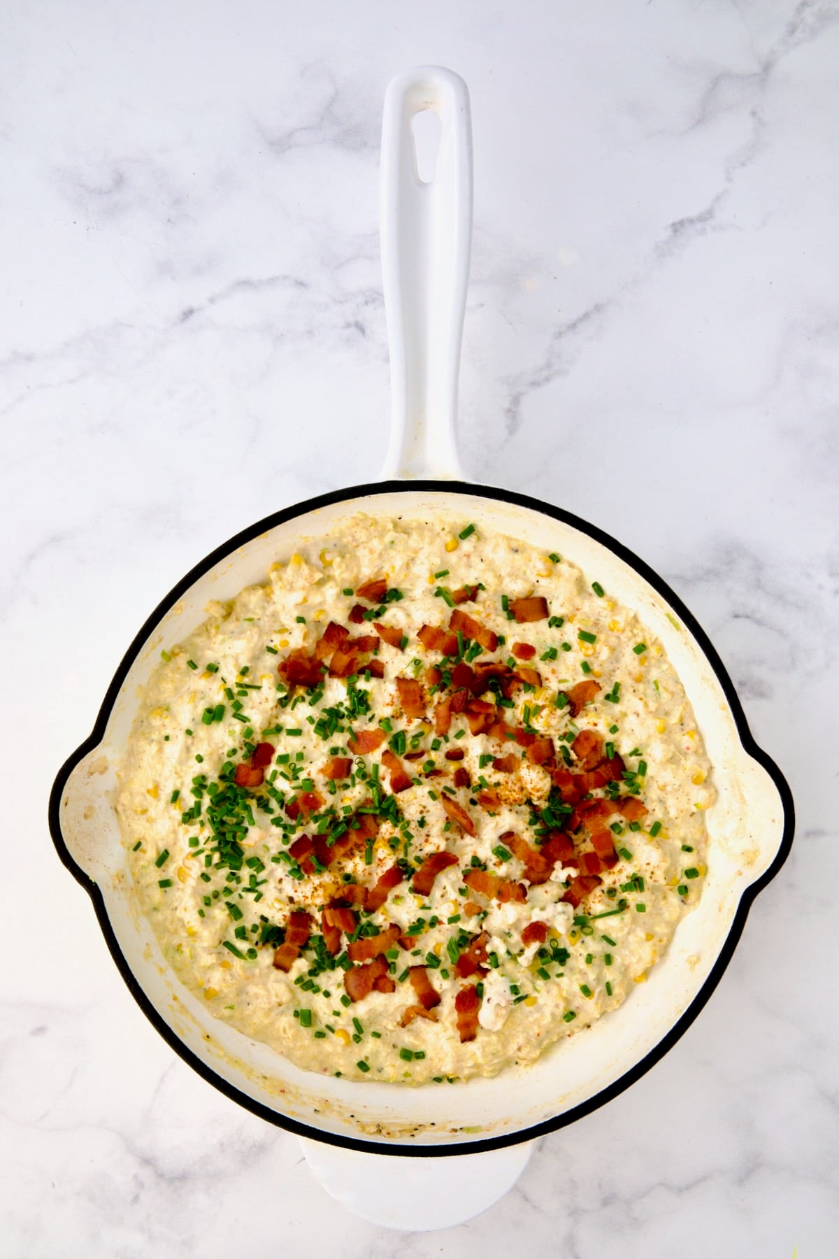 Finished smoky sweet corn puree in white enamel cast iron skillet.