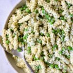 Creamy Cucumber Pasta Salad in white serving bowl with serving spoon.