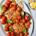 Salmon with Balsamic Cherry Tomatoes on oval white platter with serving fork.