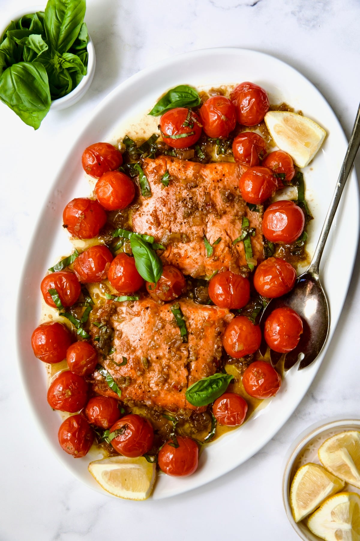 Salmon with Balsamic Cherry Tomatoes on oval white platter with serving fork.