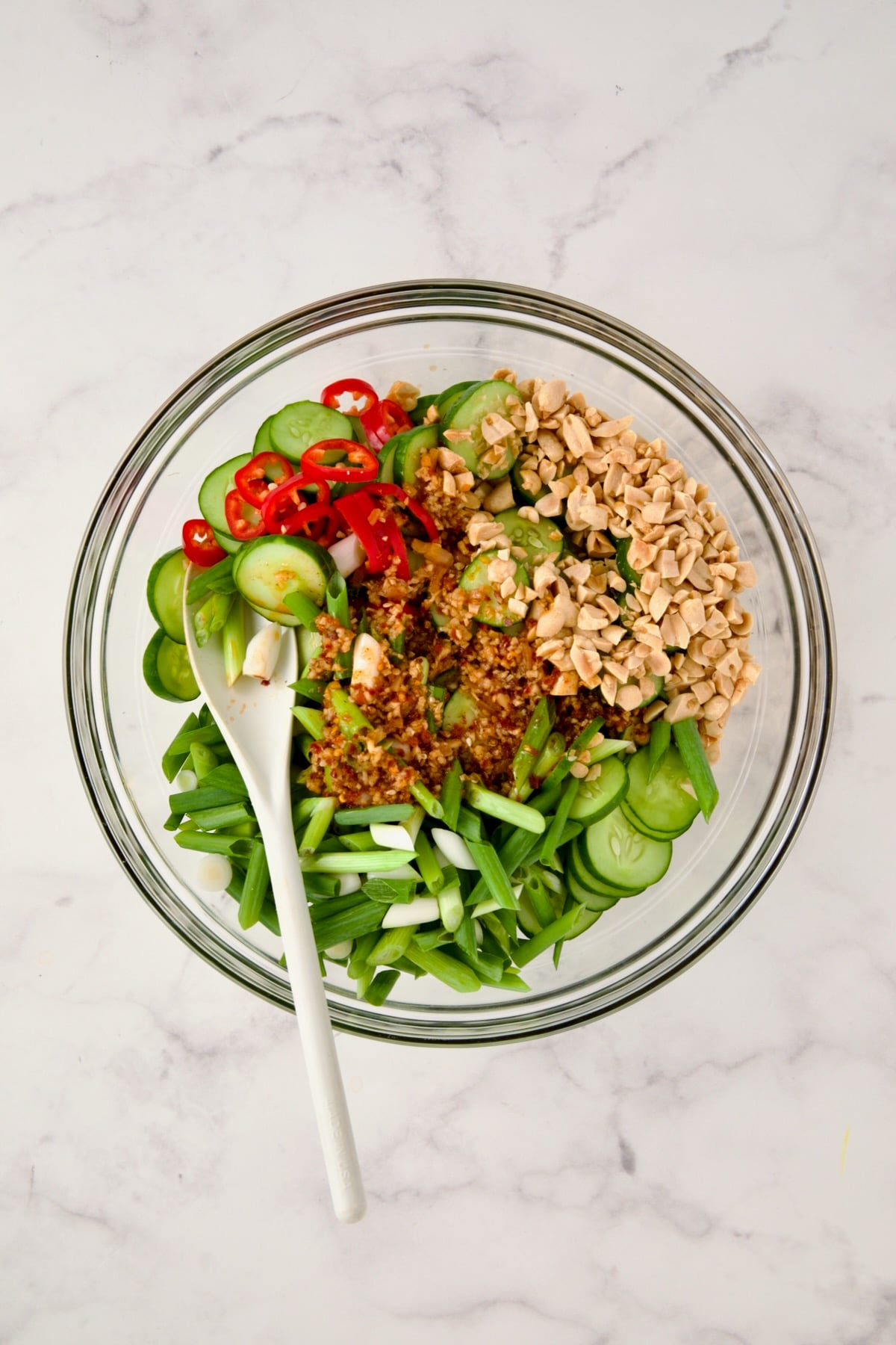 Ingredients for Spicy Asian Cucumber Salad in glass bowl before being mixed together with dressing added.