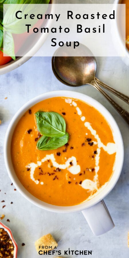 Pinterest graphic for Creamy Tomato and Basil Soup showing it in a white soup mug garnished with fresh basil, cream and red pepper flakes.