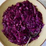 Sweet and Sour Red Cabbage in earthenware bowl with serving spoon.