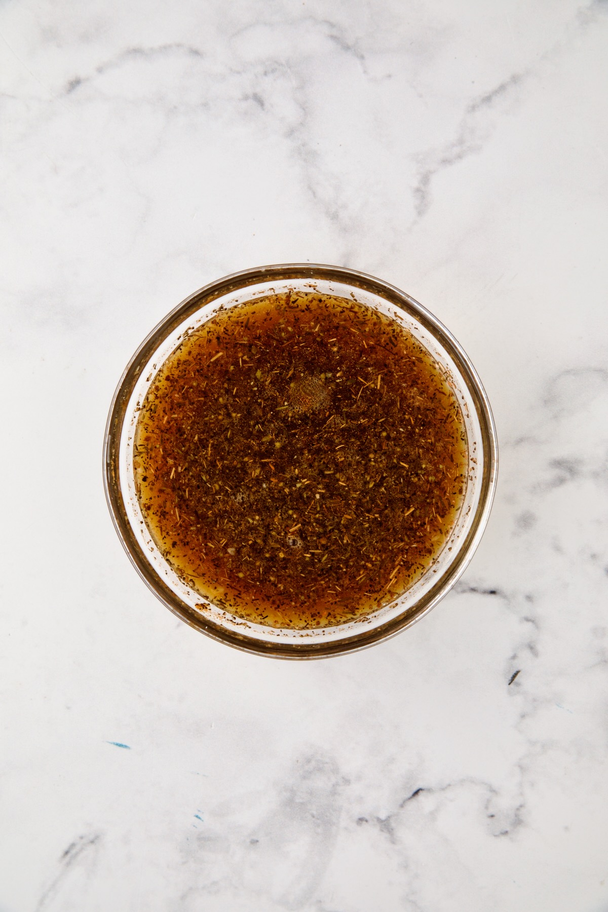 Herb and broth blend in glass bowl.