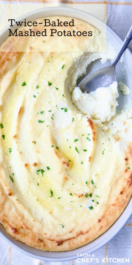 Pinterest graphic for Twice-Baked Mashed Potatoes showing them in an oval baking dish with serving spoon scooping some out.