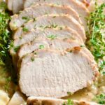 Braised Pork Loin in Dijon Mustard Sauce garnished with thyme sprigs.