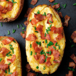 Twice-Baked Potatoes with Cheddar and Bacon on a baking sheet.