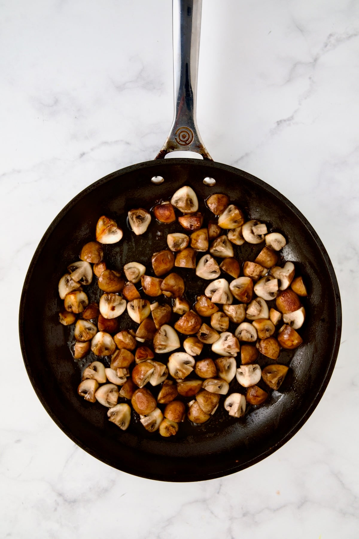 Browned cremini mushrooms in nonstick skillet.