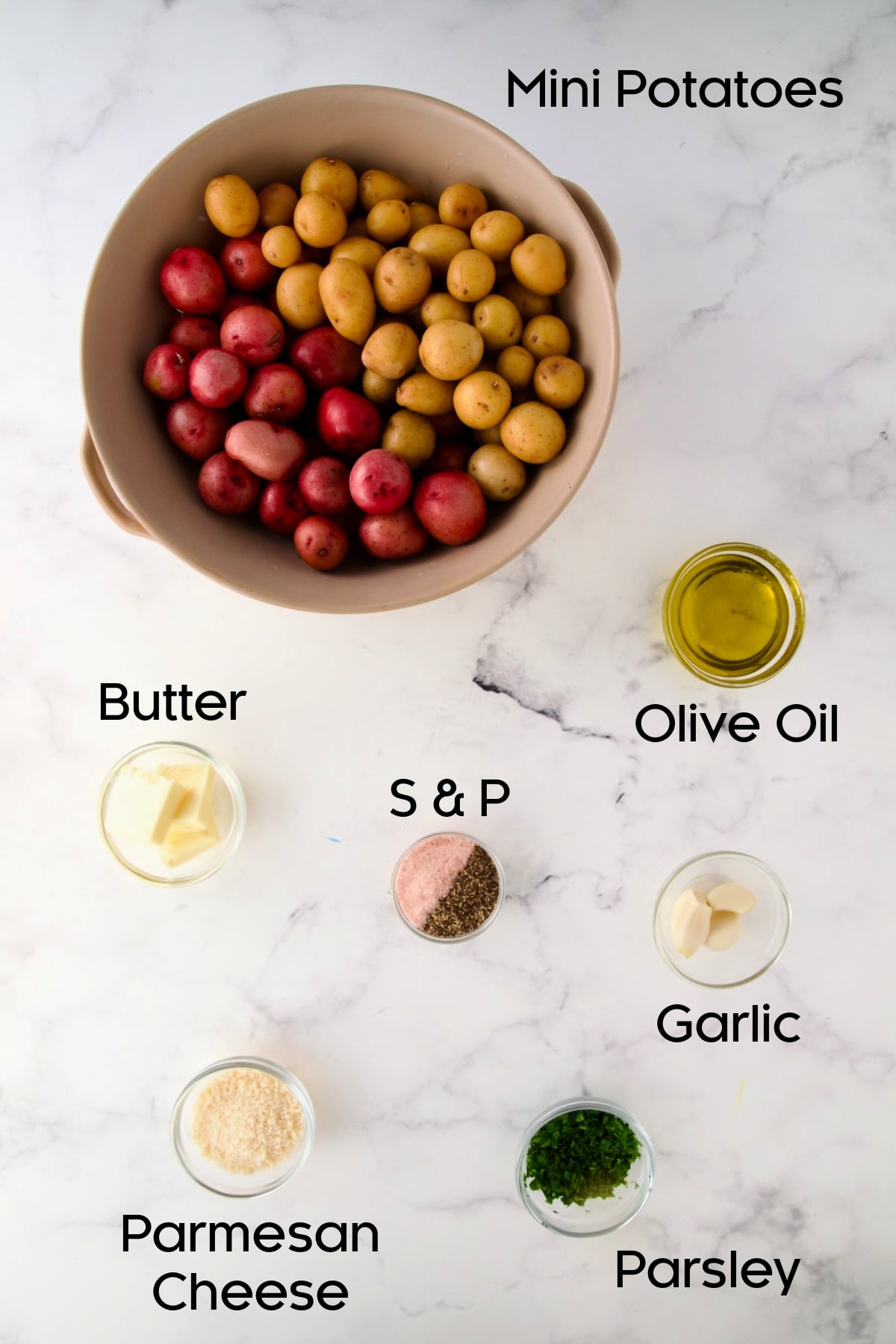 Ingredients for Garlic Butter Parmesan Mini Potatoes in glass bowls with potatoes in a colander.