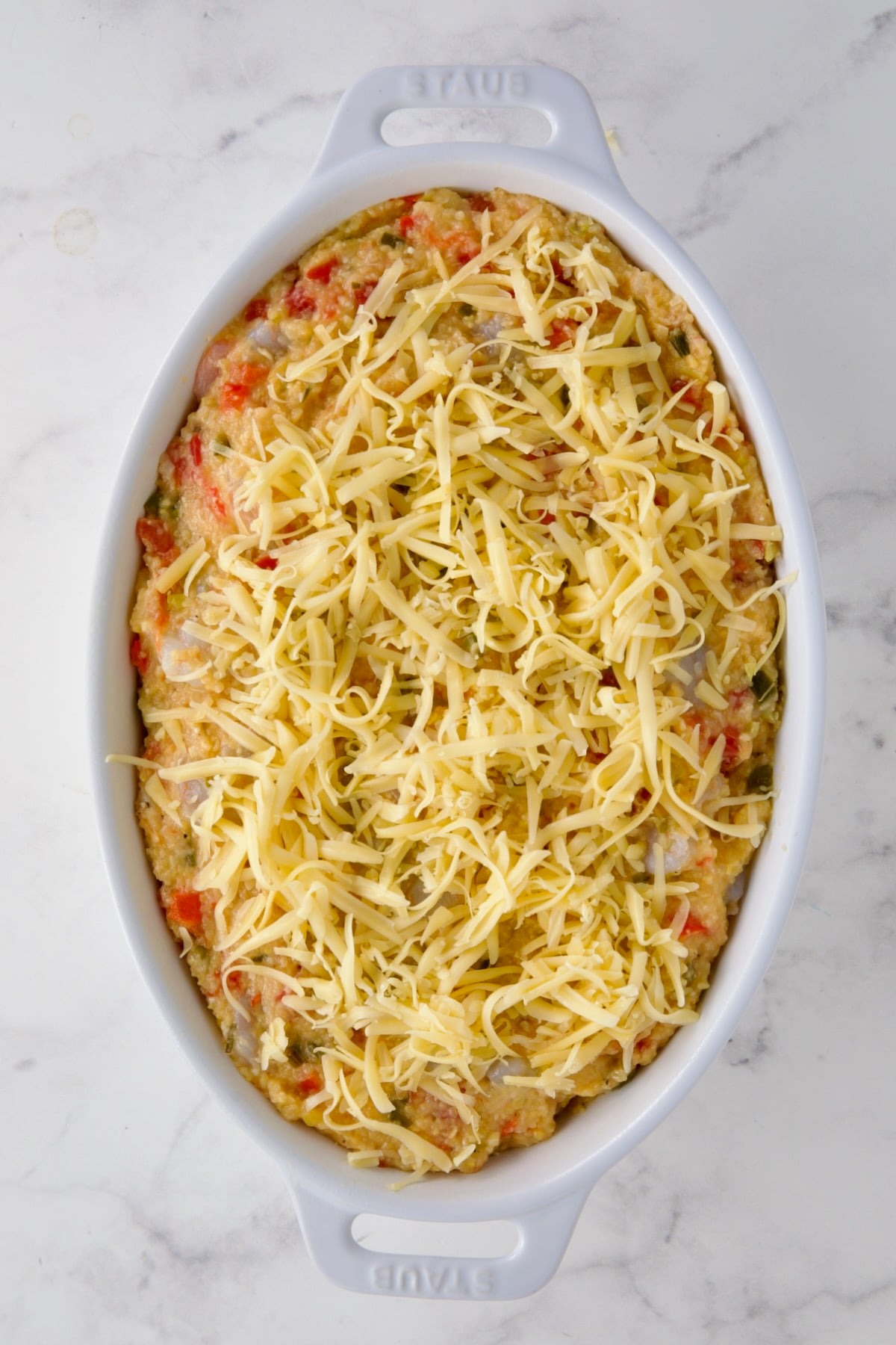 Shrimp and Grits Casserole in oval baking dish before being baked.