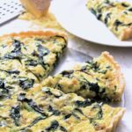 Rustic Greens, Leek and Gruyere Tart with two wedges cut out.