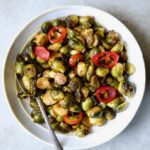 Hot Honey Brussels Sprouts in white serving bowl with serving spoon.