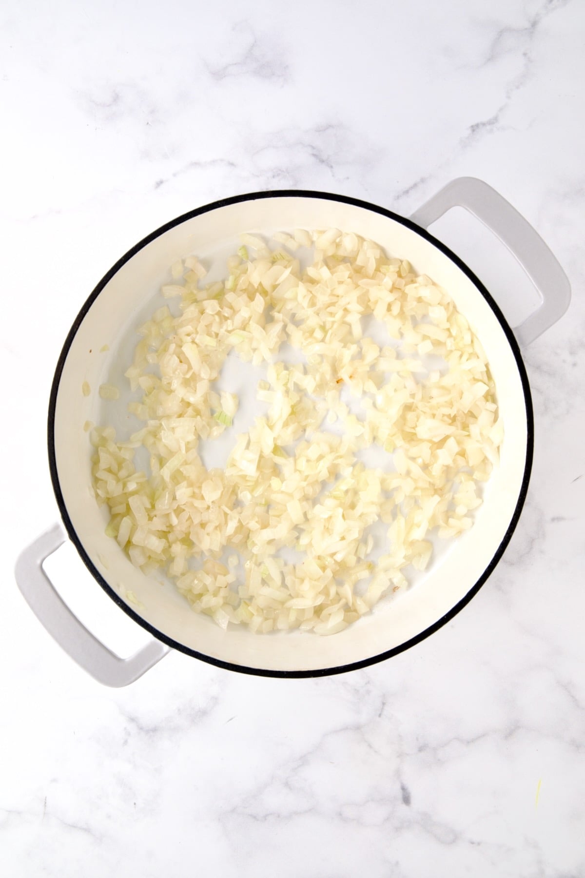 Cooked onions in white enamel cast iron skillet.