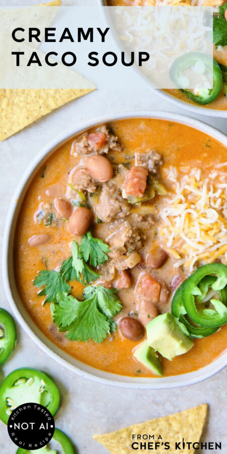 Pinterest graphic for Creamy Taco Soup showing one serving in a white bowl garnished with tortilla chips, avocado, jalapeno and cilantro.