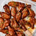 Hot Honey Chicken Wings on parchment paper lined platter with basting brush.