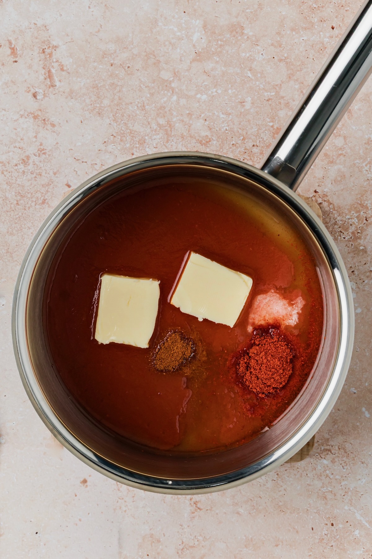 Sauce ingredients in stainless steel saucepan before being cooked.