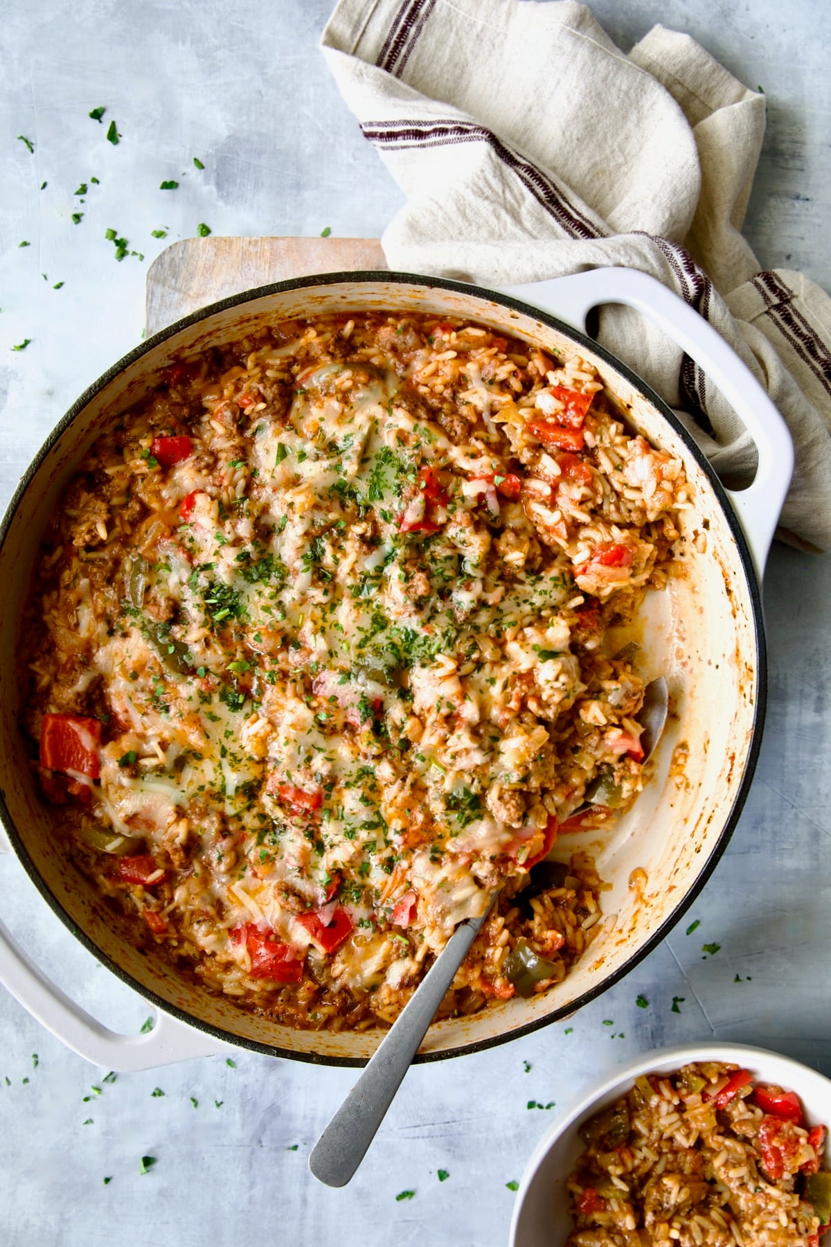 Unstuffed Peppers Skillet in white enamel cast iron skillet with some served up in white bowl.