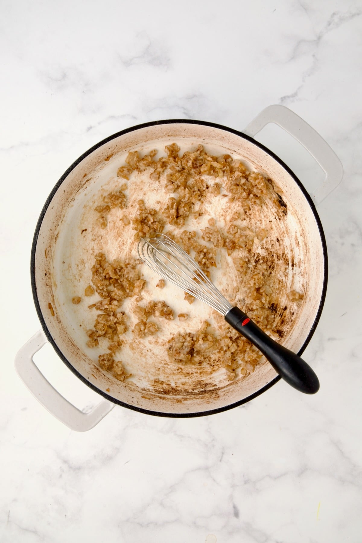 Cooked onions and flour in white enamel casit iron skillet.