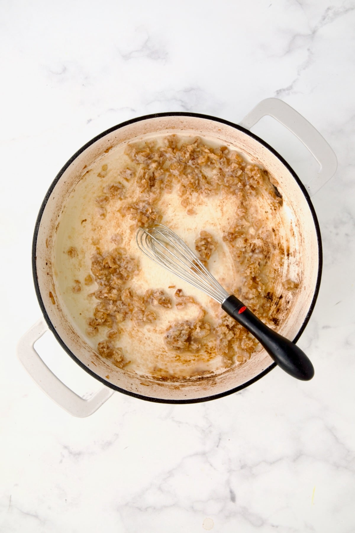 Dry white wine added to onions and flour in white enamel casit iron skillet.
