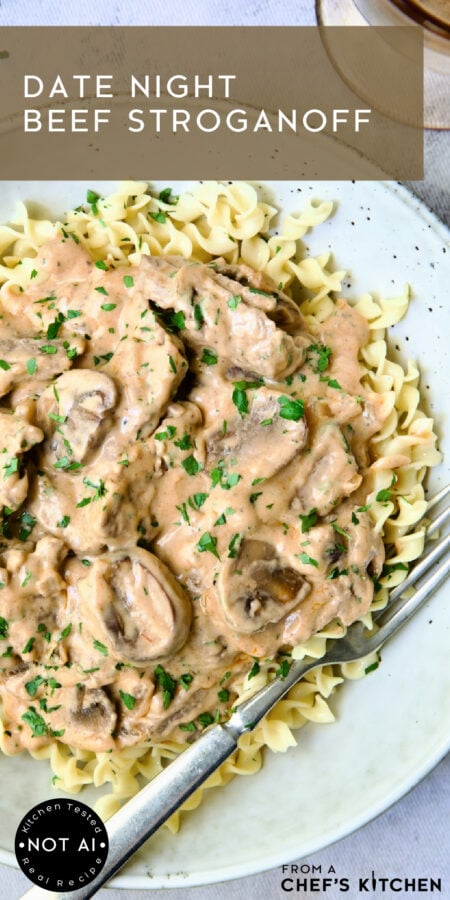 Pinterest graphic for Date Night Beef Stroganoff showing it in an earthenware bowl over egg noodles.