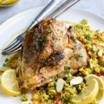 One serving of Moroccan Chicken with Jeweled Couscous on round white plate.
