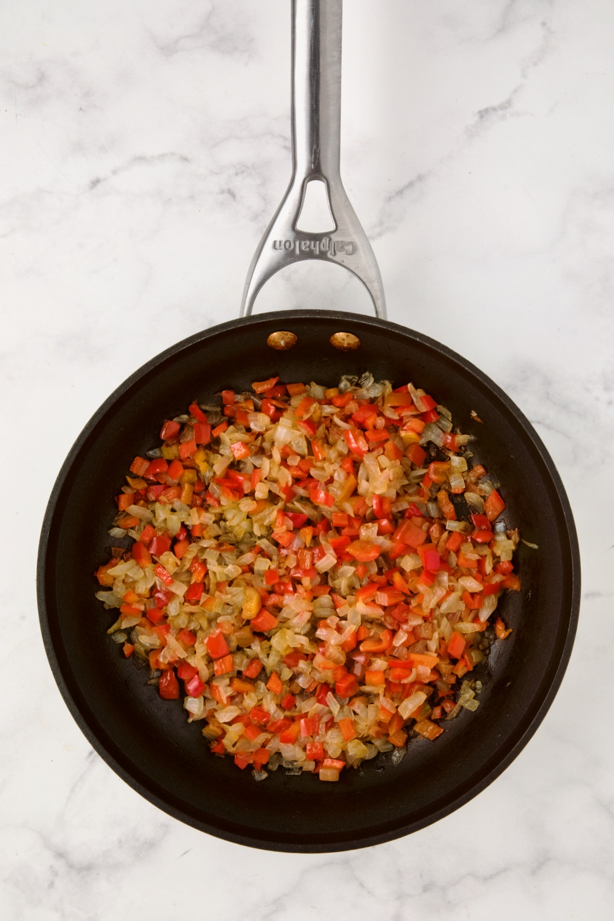 Cooked onions and red bell pepper in nonstick skillet.
