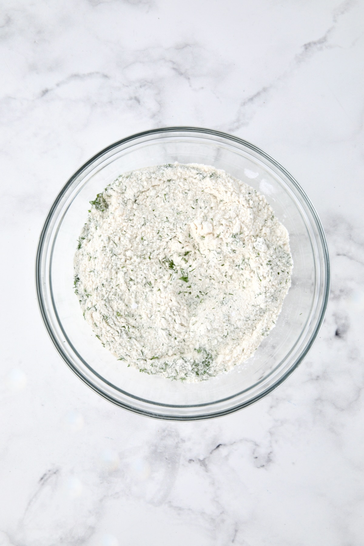 Dry ingredients for muffins in a glass bowl.