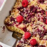 Easy Raspberry Coffee Cake cut into pieces with pie server picking one up.