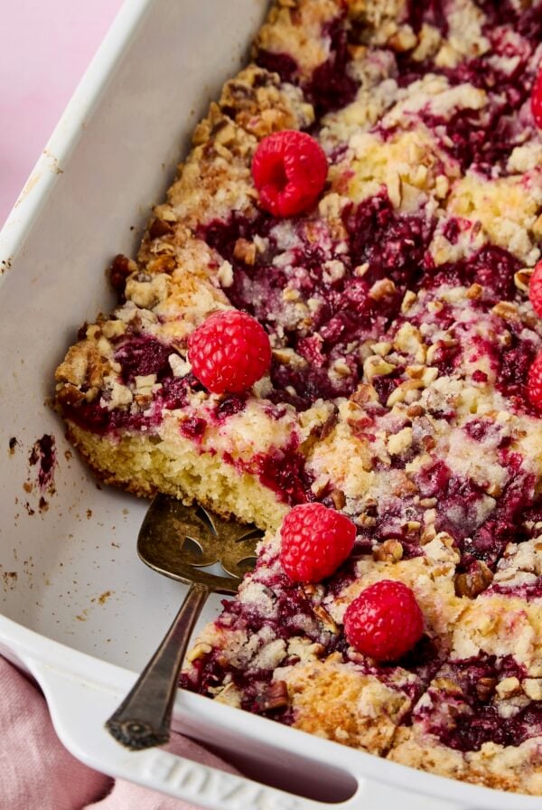Easy Raspberry Coffee Cake cut into pieces with pie server picking one up.