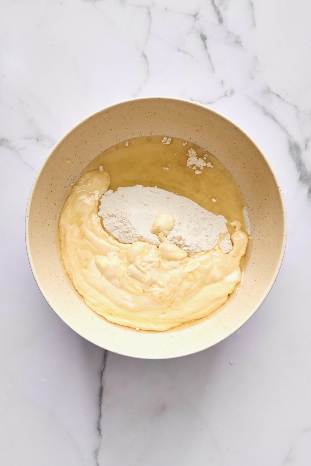 Wet and dry ingredients for coffee cake combined in bowl.